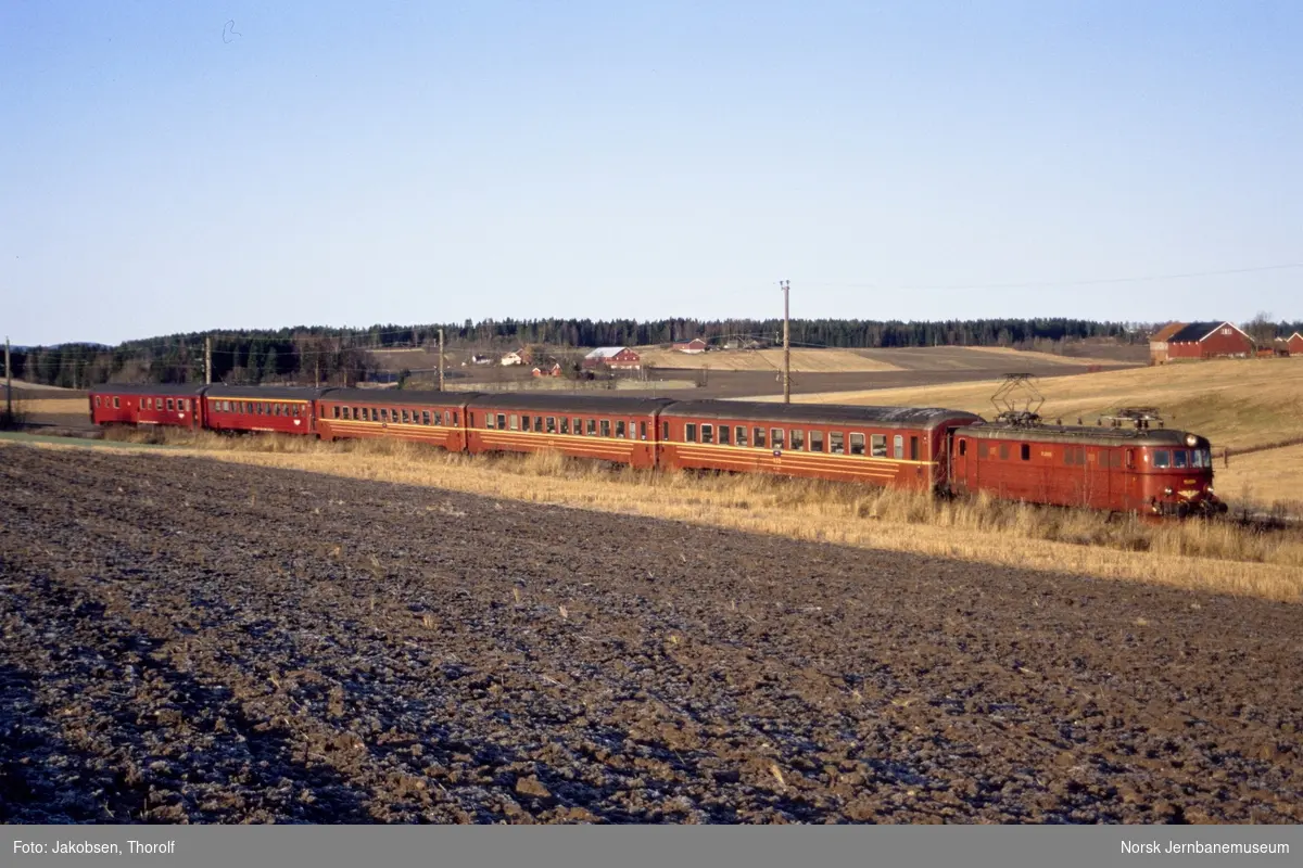 Elektrisk lokomotiv El 11 2095 med persontog fra Halden til Oslo S mellom Holstad og Ås stasjoner på Østfoldbanen