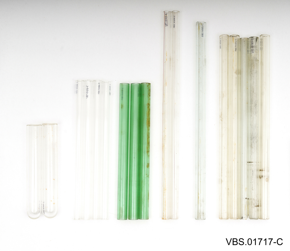 Aluminiums eske med, uten lokk, og to håndtak. Den inneholder et metallstativ med flere reagensrørholder eller glassrør.
Aluminiums eske (A), stål stativ (B) og glassrør (C) på bilder.

Glassrør settet består av: 
2 hvite glass prøverør (13x2cm diameter). Brukte.
3 grønne glassrør (20x1,5 cm diameter). Brukte.
5 hvite glassrør (28x1,5 cm diameter). Brukte.
3 hvite glassrør (50x1,5 cm diameter). Brukte.
4 nye hvite glassrør (28x1,5 cm diameter). Brukte.