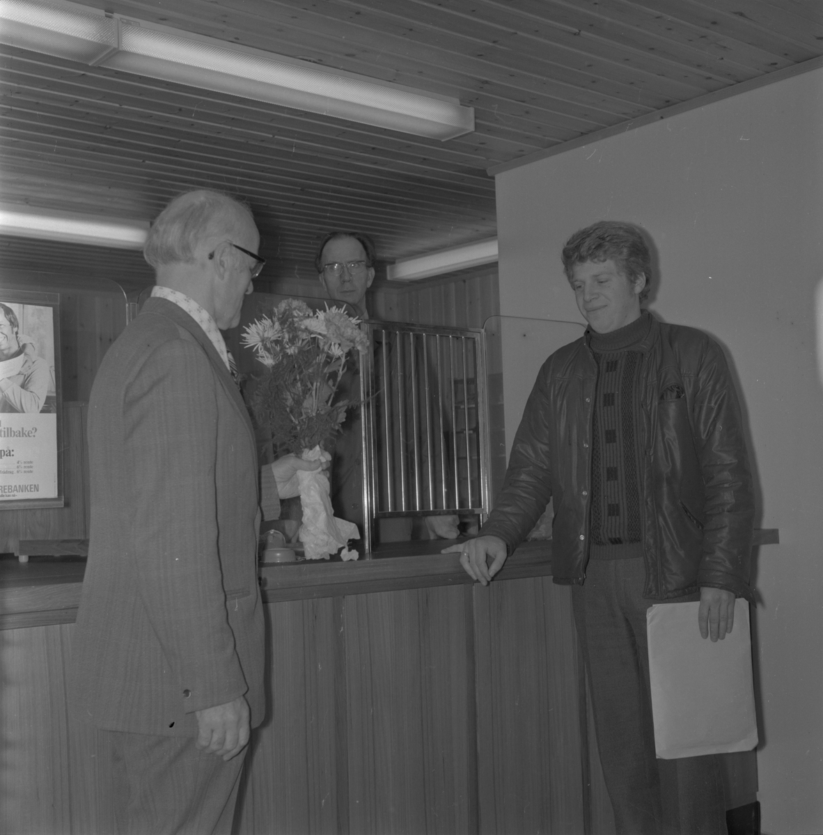 Opninga av det nye postlokalet på Kvassanes i Ølensvåg, 1974. Utdeling av blomster til første kunde. Frå venstre: postsjef Mønichen frå Haugesund, poststyrar Brekke og første kunde Noralf Matre frå Ølen.