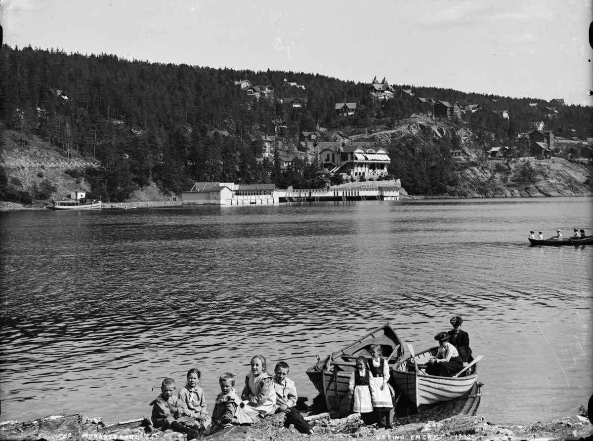 En gruppe barn i stranskanten på Ulvøya. I bakgrunnen sees Nordstrand bad.  
