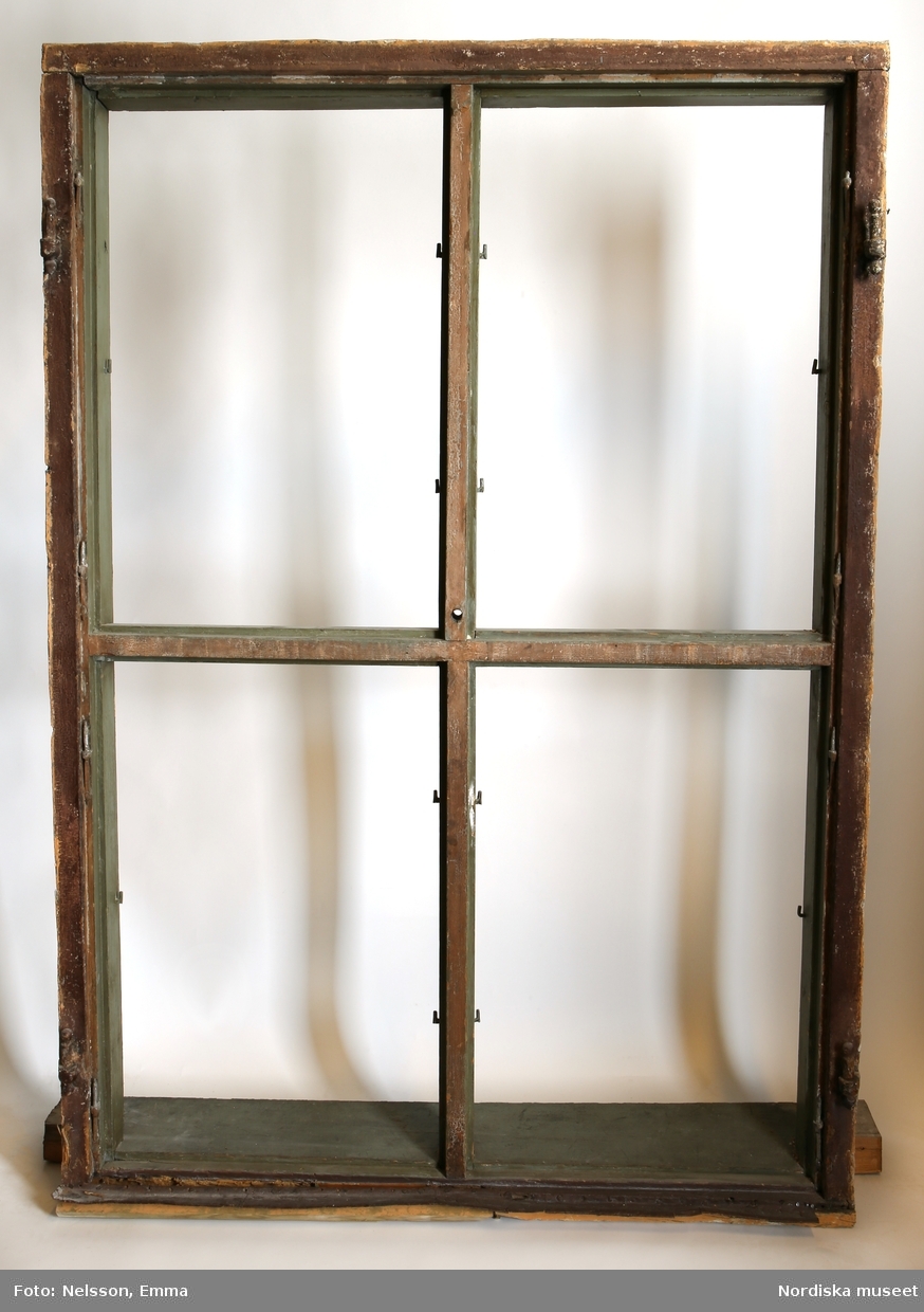 a-d) Fönster med e) karm, fyra fönsterbågar med vardera sex glasrutor, omkring 1740. Utvändigt målat brunt, invändigt grågrön oljefärg. 

Utåtgående fönsterbåge. Träspröjsar med en på insidan rundad vulst som möts i kvadratiskt spröjskryss. Bågens yttersida förstärkt med hörnjärn av 1700-talstyp. Fönsterkarm av furu med symmetrisk korspost. Fönsterbleck av målad plåt, fäst i karmens nederkant. Med fönsterbräda. Beslag för hängning av fönsterluckor. Gångjärn, uppställnings- och stängningsbeslag.  

Anm: Partiellt färgbortfall och skador. Ett av tre fönster(NM.0334543-NM.0334545), placerat på rummets långsida, mot gatan.
/Anna Arfvidsson Womack 2021-07-14