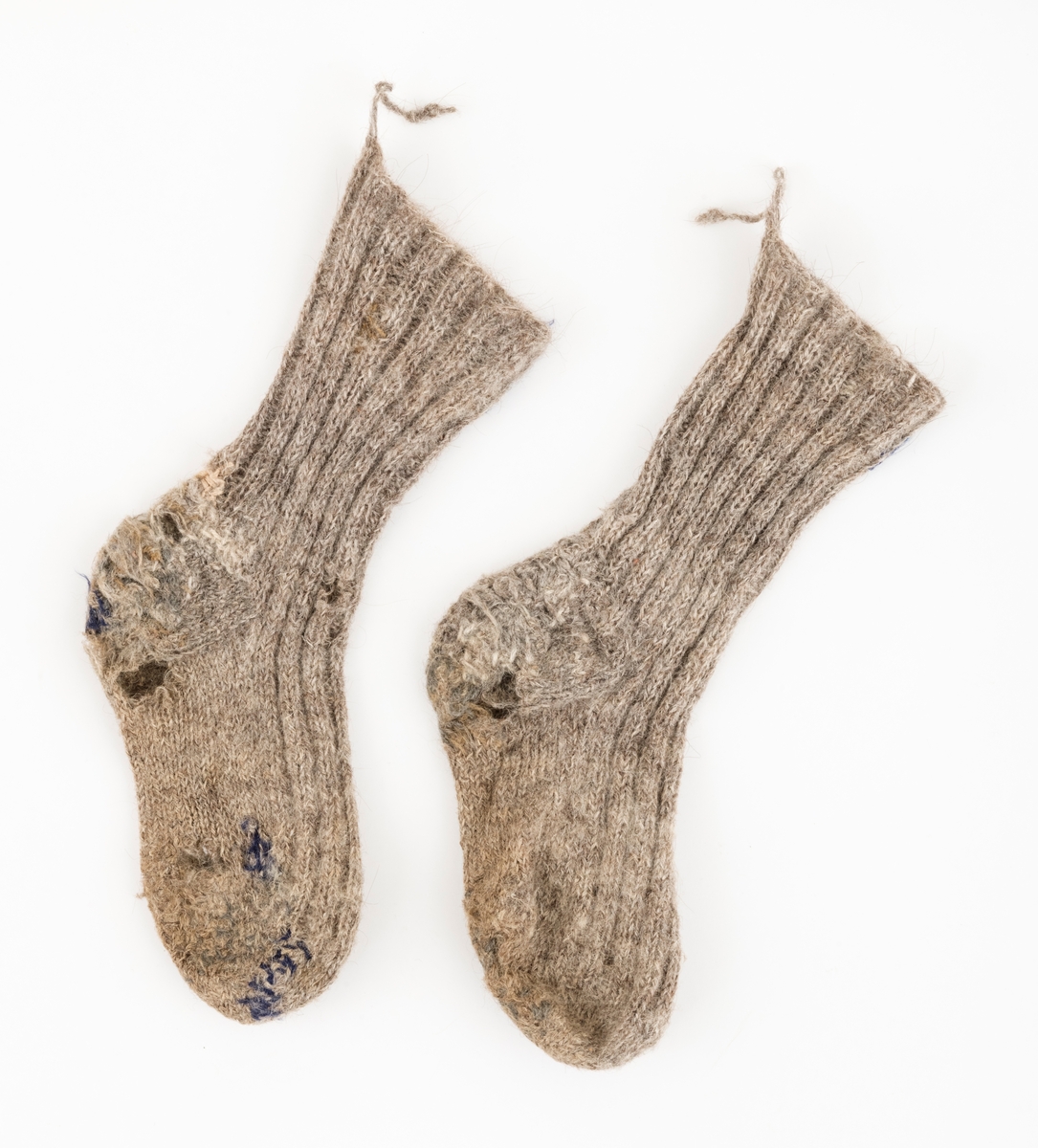 Ett par sokker som er strikket av grått ullgarn. Brukt av giverens onkel, Karl Galåsen. (1874-1962)