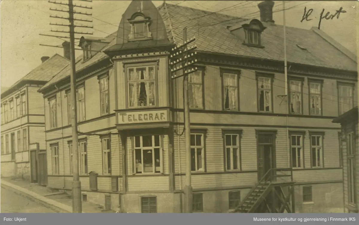 Postkort med bilde av Telegrafenstationen i Hammerfest på forsiden. Et skilt på bygningen annonserer "Telegraf." og en trapp fører opp til døren til høyre. Foran hus står to stolper. Husets tak er skiferbelagt. Postkortet er adressert til skiverens mor, Fru Provst Balke i Vadsö og datert den 19.12.1909.