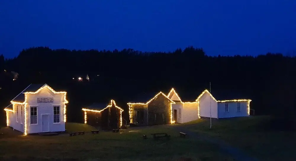 Prærielandsbyen i vintermørke med silhouett av lys