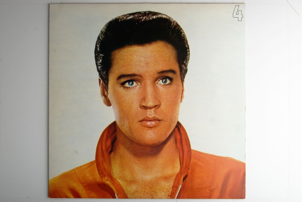 Bilde av Elvis Presley. Synger og har en gitar rundt livet.