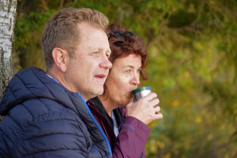 Foto av en mann og en dame som drikker kaffe ute i naturen