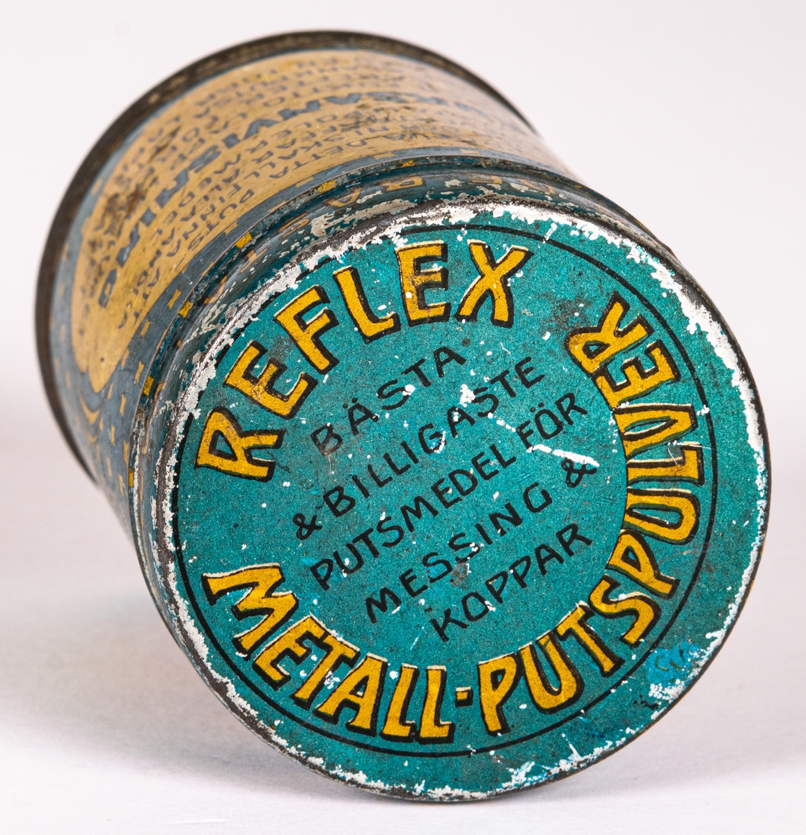 Plåtburk med blå  och gult tryck. Har innehållit Reflex-metall-Putspulver. Från B. Södergrens kemiska fabrik.