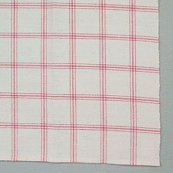 Handduken har en vidhängande pappersetikett med texten: Handuksväv formgiven av Margit Westin. Väverska troligen Gunilla     ?           , framtagen till linutställningen 1984, länsmuseet.