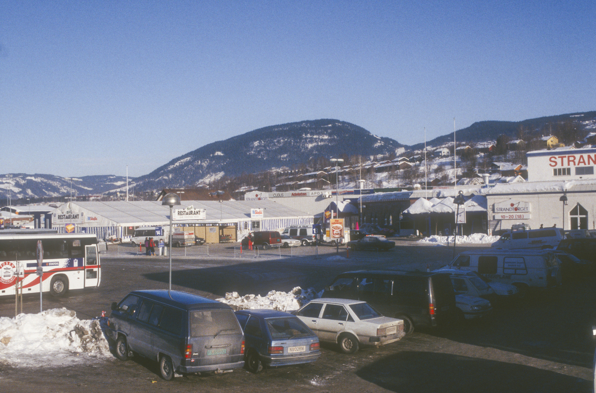 Lillehammer under OL 1994. Strandtorget.  Liten del av midlertidig bussholdeplass i venstre billedkant. Restauranttelt med bar, fastfood og pizza i bakgrunnen. Sett mot nord.