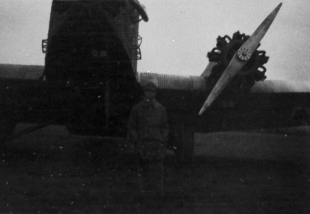 En man står framför flygplan Junkers Ju 53 på ett flygfält.
