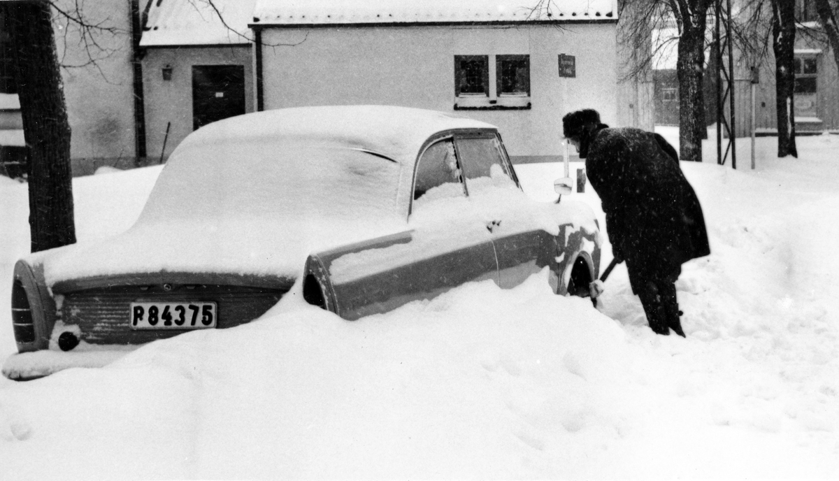 En man skottar fram sin bil vid stadskyrkan någon gång under vintern 1966.