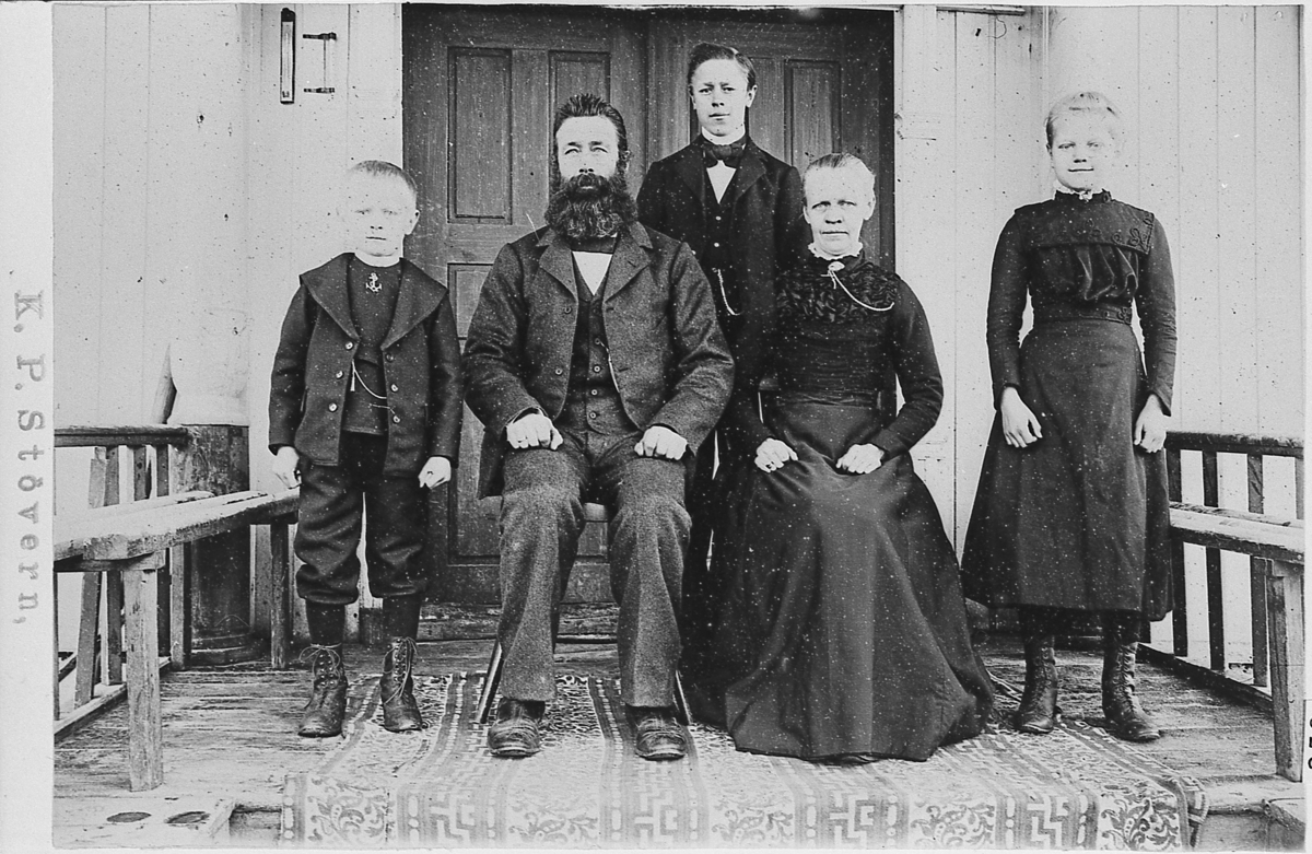 Familieportrett Hunstad, 1901. Bakerst Helge og Borghild. Fra venstre foran står Kristoffer og ved siden av han sitter Torger og Gunhild. Ute på trammen foran dobbelt inngangsdør.