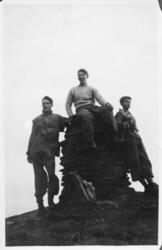 Tre menn ved en varde på toppen av Høgfjellet.
