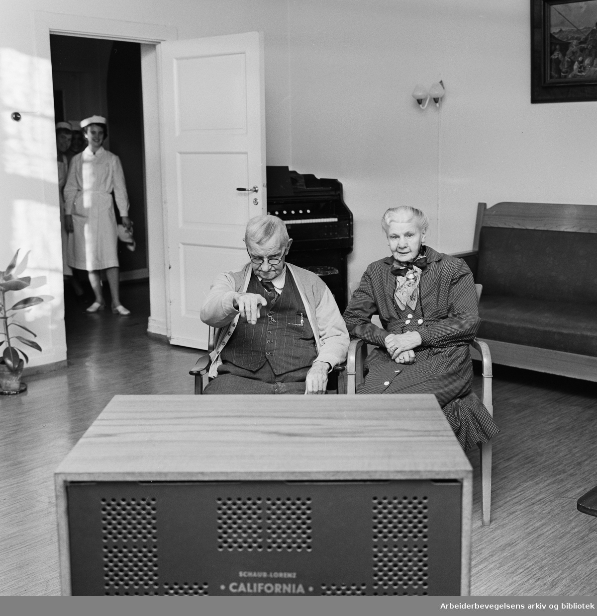 Adamstuen aldershjem har fått tv. Beboerne Eugen Olsen og fru Holst Jensen følger interessert med. Januar 1962