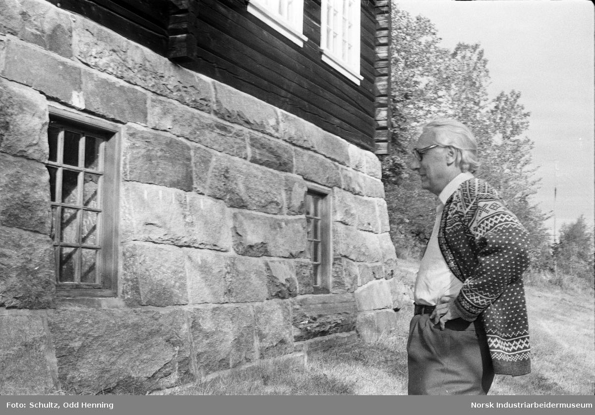 Mann ved grunnmuren til laftehus i Øyre Gjøystdal.
