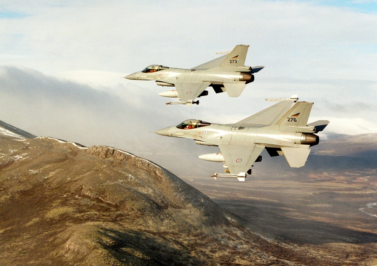 To F-16 over fjellandskap.