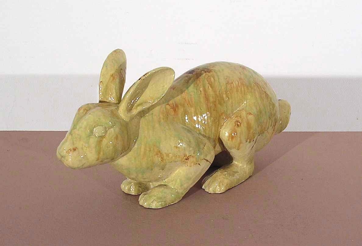 Hare i glaserad keramik, färgen är gulaktig med inslag av brunt och grönt.
