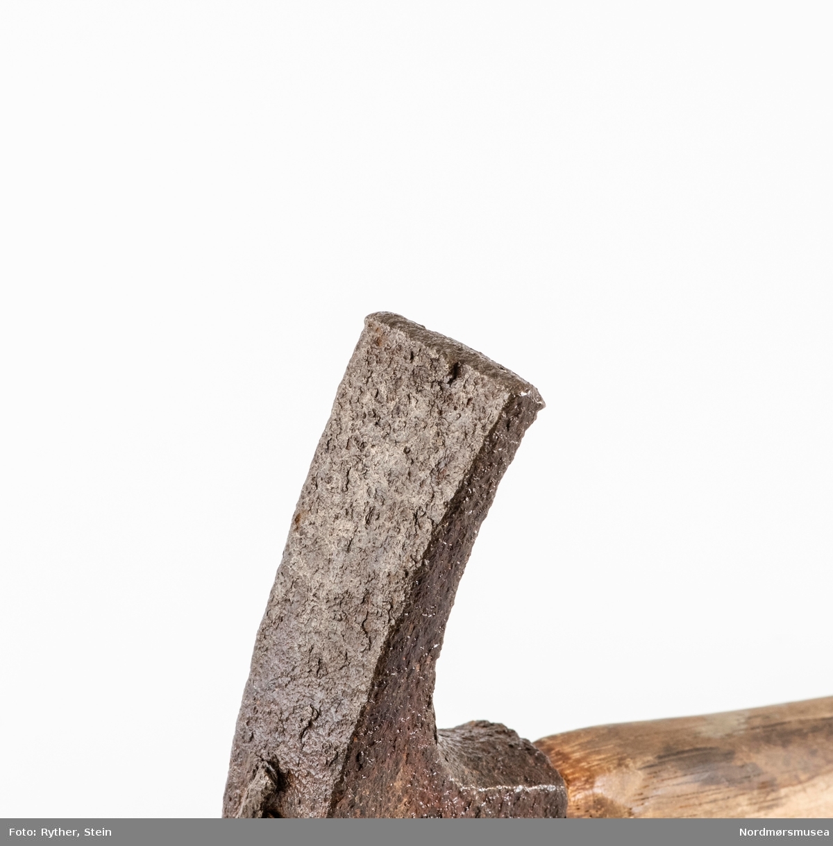 BESKR: JFR: KM.00920. Skaft med ovalt tverrsnitt. Kraftig jernhode, 4-kantet hammer (bane) på den ene enden, stump etter avbrukket tverrøks på den andre. 
BRUK: JFR: KM.00920.