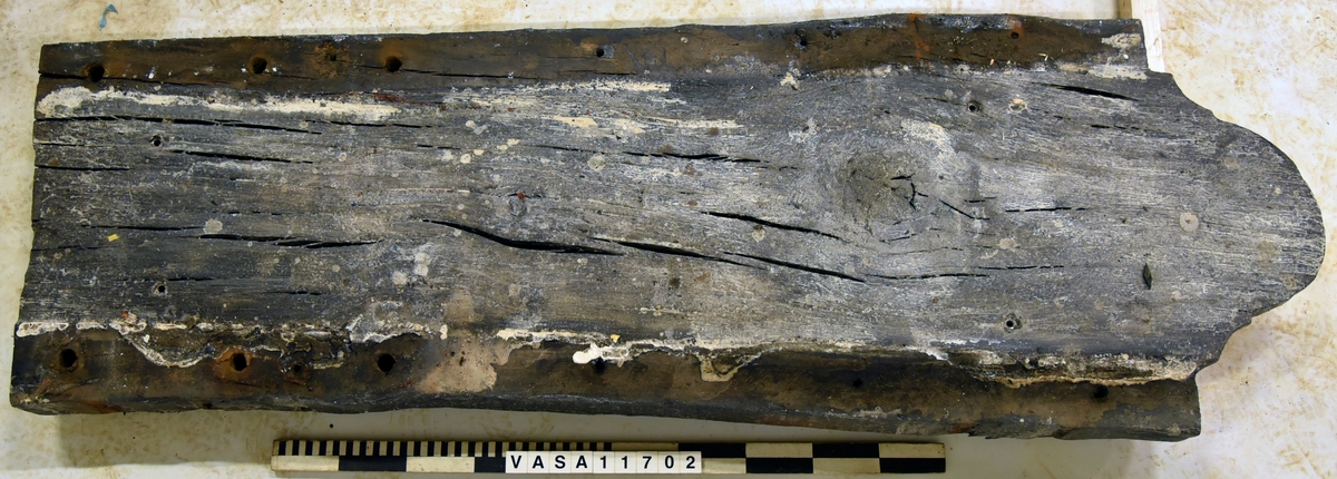 Lavettbotten, flertal sprickor med splitter, stor trä knut i mitten.

Heavely cracked split gun-bed, large central knot.