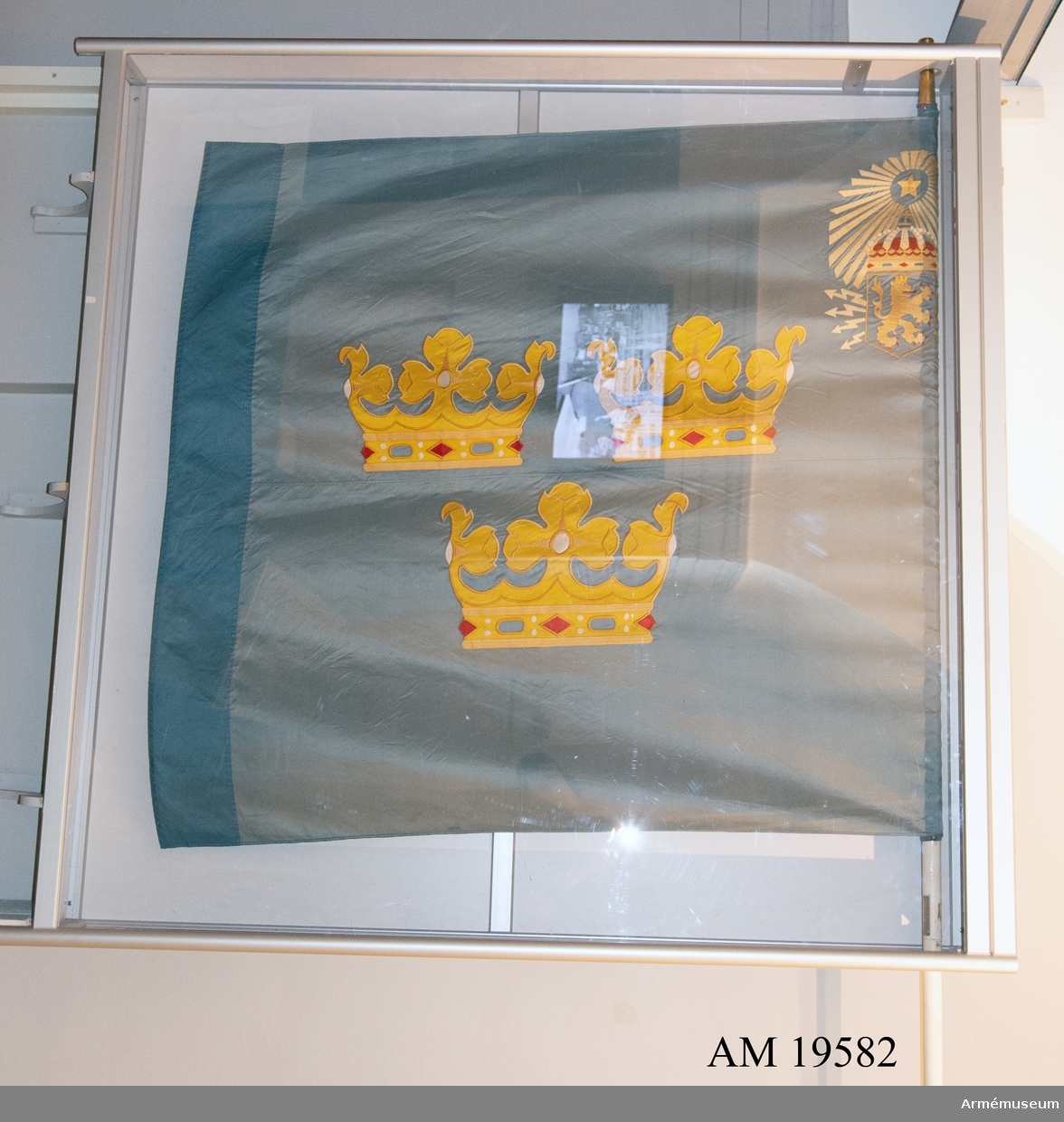 Fanans mittmotiv består av tre öppna kronor. I övre inre hörnet finns  en stjärna i strålglans och under den ett lejon i sköld med strålknippe. Motiven är handbroderade. Duken är mycket skör och blekt.  På stången finns en sliverplatta monterad med texten: "Ur konung Gustav VI Adolfs hand i Karlsborg 19620625".
