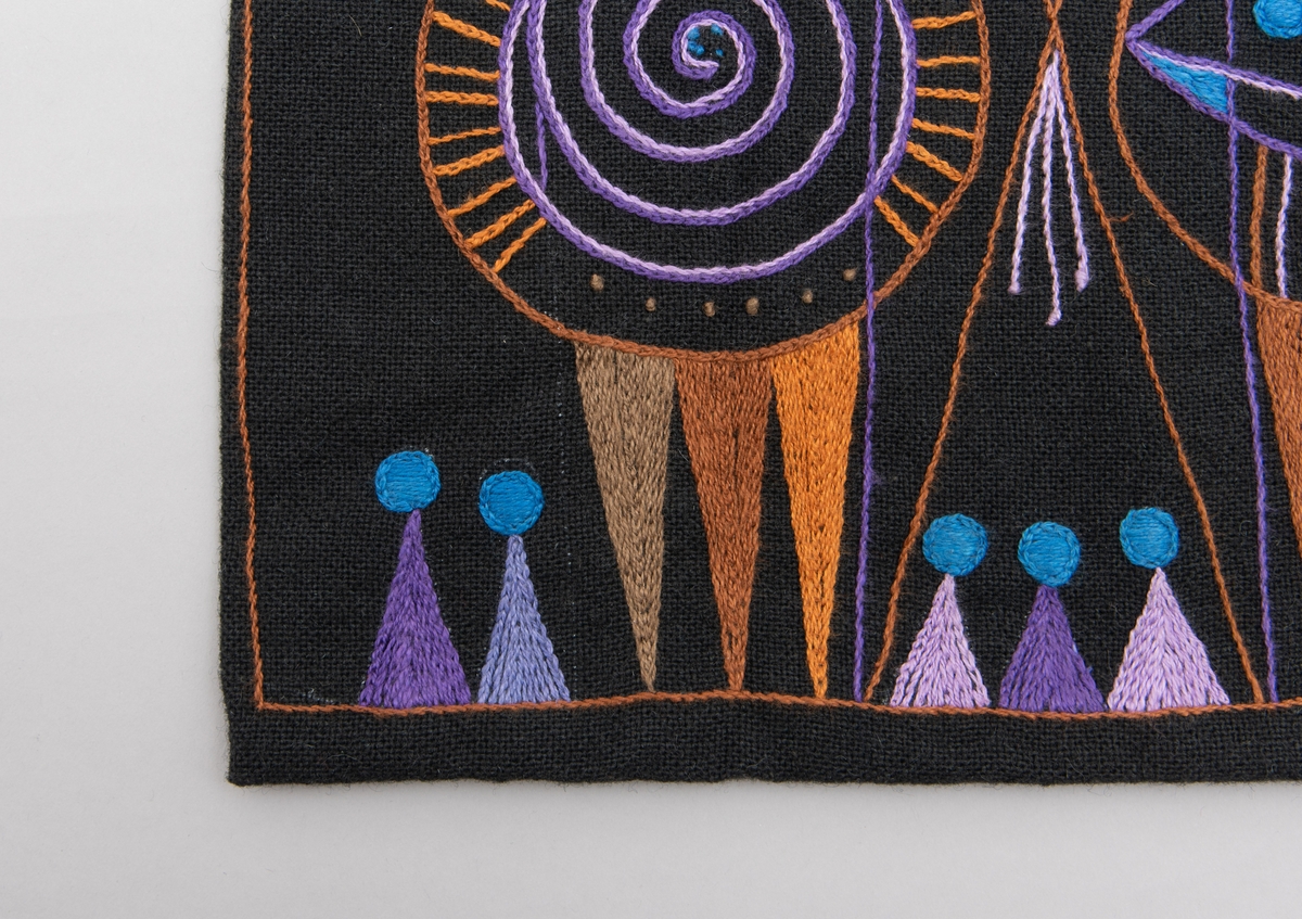 Svart tekstilpose med broderi i oransje, lilla og blå. Geometrisk design. 