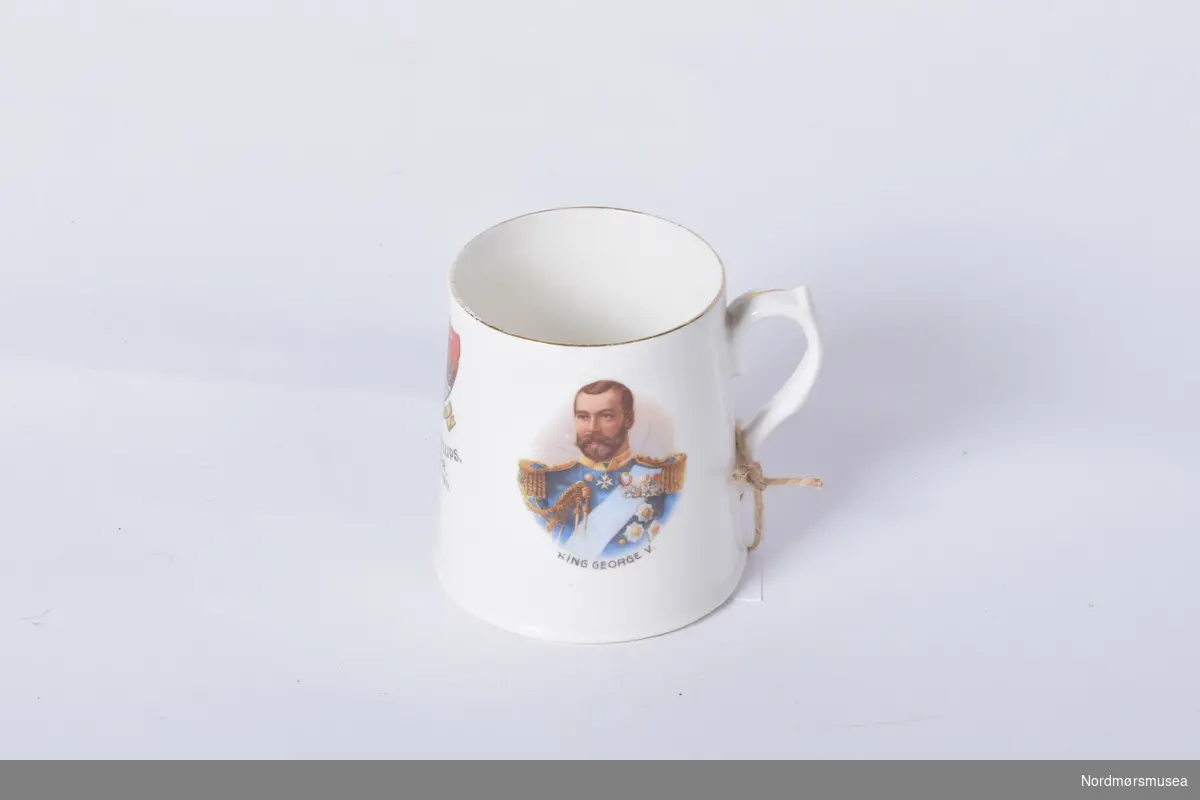 Hvit kopp med gullfarget rand. Våpenskjold til Dartmouth og portrett av kong George og Dronning Mary.