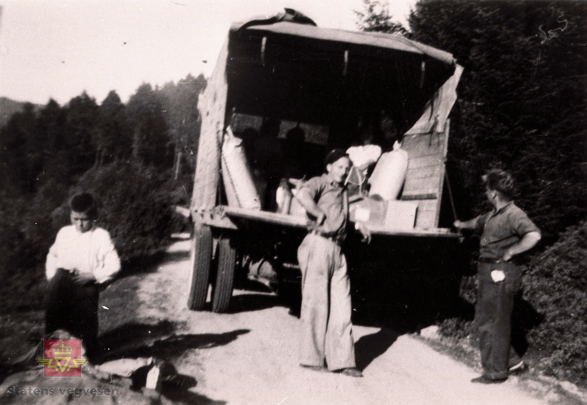 Ein lastebil på stykkgodsrute med sjåfør, medhjelpar og ein ung gutt.

Bilete er tatt ein eller annan stad i Sogn og Fjordane.