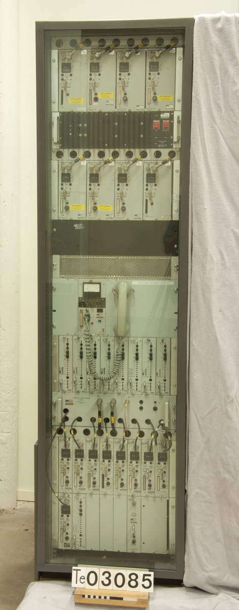 Radiobasstation för NMT 450. Stativ med åtta kanaler. Använd med filterstativ, se TM48052.
Försedd med glas på framsidan i samband med utställning.