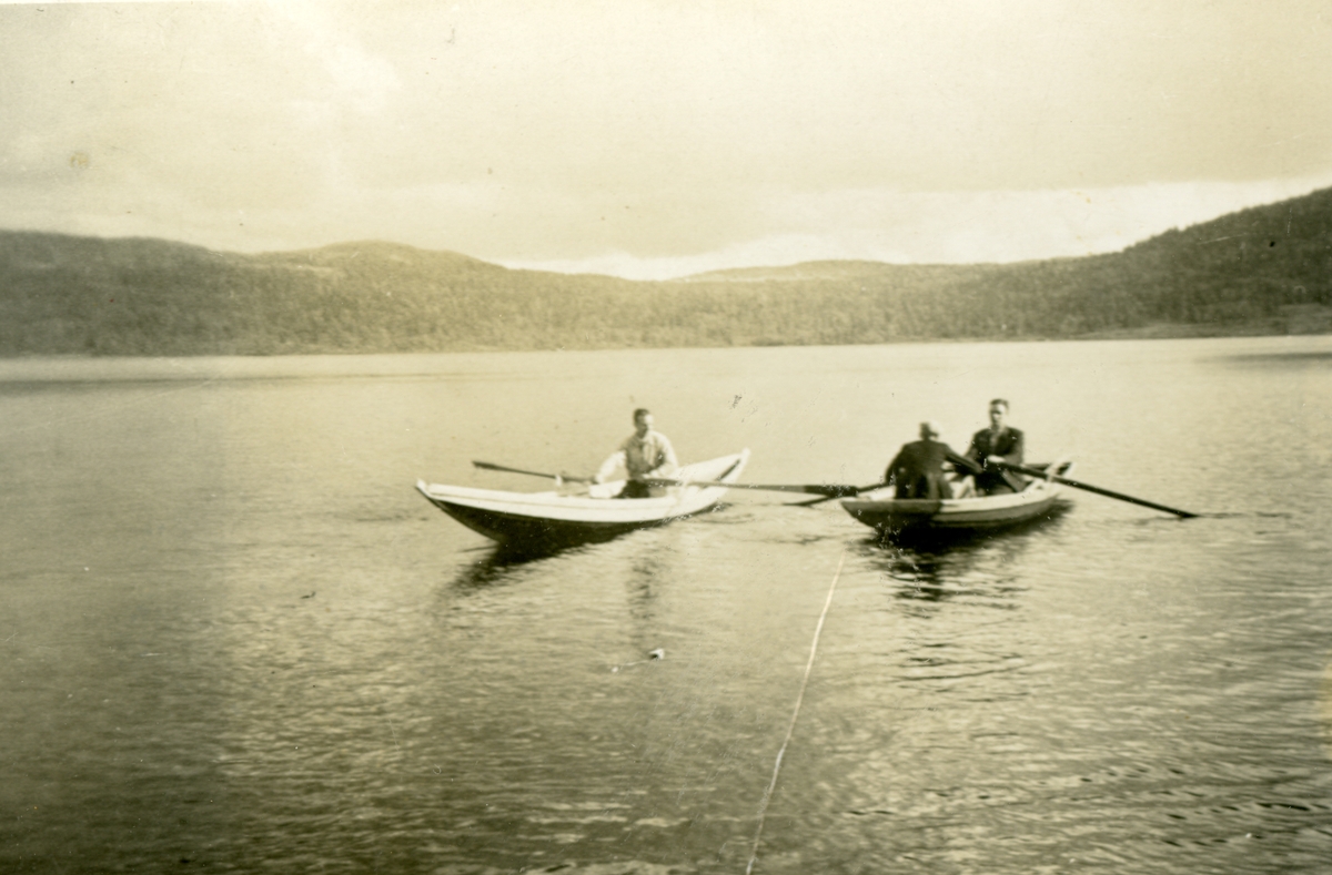 Tre personar ute i robåt på fjorden