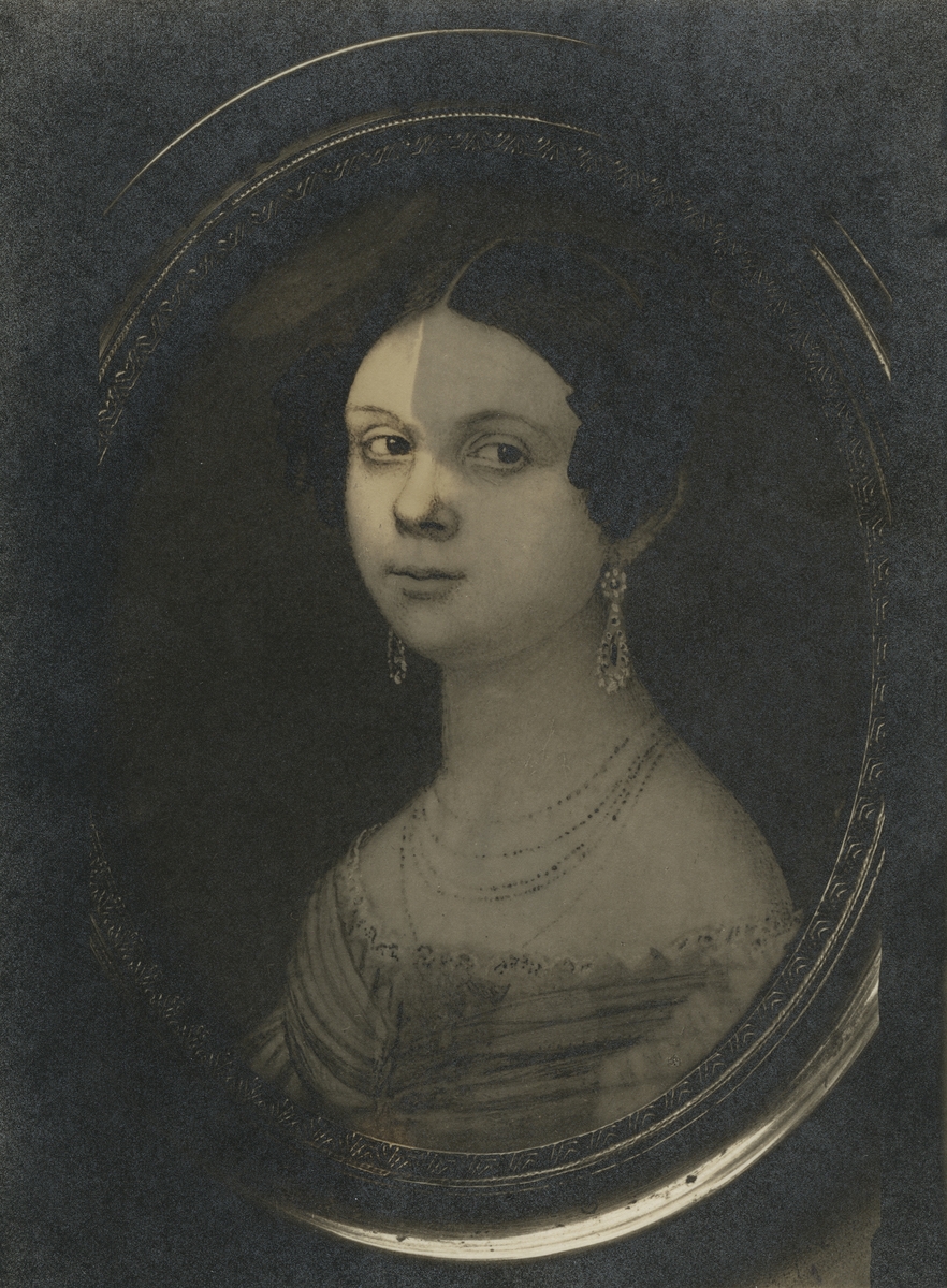 Bilden föreställer Lovisa Eugenia Holmberg (gift Flodin) född 1817-05-17 i Västerås, död 1894-11-09 i Västerås. Utförd av Johan Deshington 1858.