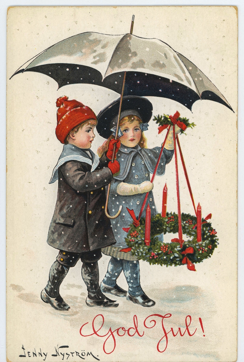 Julkort med motiv av en flicka och pojke som bär på ett paraply och en julkrans med röda stearinljus. Under barnen står texten " God Jul!". Längst ned till vänster står illustratörens namn, Jenny Nyström ( 1854- 1946). Jenny Nyström var en känd, svensk konstnär, tecknare och illustratör. 

På baksidan sitter två frimärken; ett rött 4- öres och ett brunt 1- öres. Kortet är poststämplat den 23/12- 1918.
Förlag: Axel Eliassons konstförlag, Stockholm.