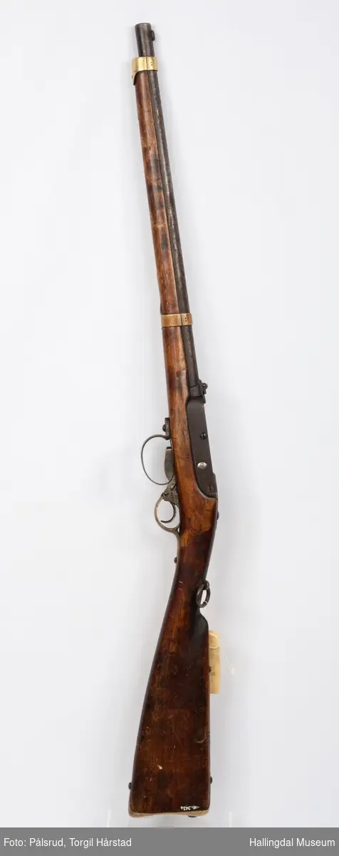 Kammerkarabin - gevær brukt av kavaleriet. To bånds gevær - har to messingbånd rundt løpet. Geværet har en kolbekappe av messing. Mangler reim.
Modell laget i 1857 (antatt ute på prøve), låsekassen har inskripsjon 1858 22 - 1858 er produksjonsår og 22 er produksjonsnummer.
Kaliber: 12 mm. 
Produsert på Kongsberg.