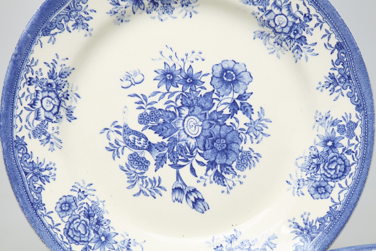 Fire hvite tallerkener dekorert med blått fasanmønster.