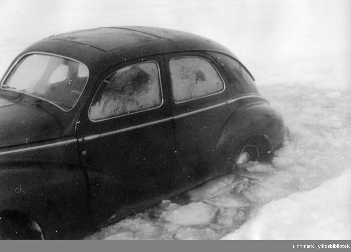 En Peugeot 203 personbil har problem på isveien, Tanaelva. Å komme opp i en sånn situasjon kunne bli svært dramatisk. Når isen smelter kan det fort bli farlig å krysse elva over isen.