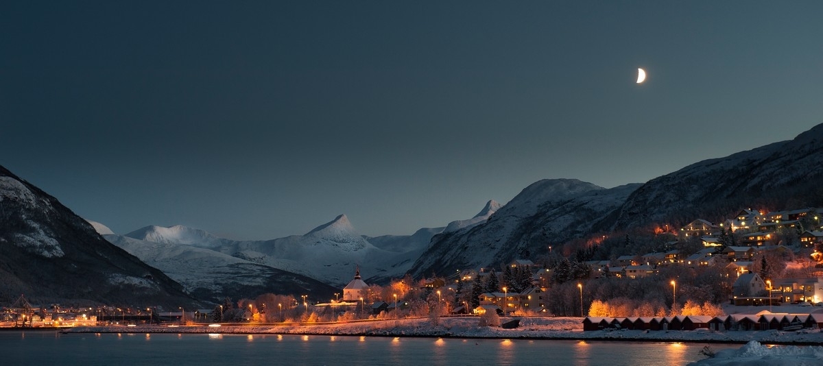 Foto av fjell innafor Beisfjord, bl.a. Vombtind.. Også E6 og Ankenes kirke. Foto fra molo på Ankenes i Narvik kommune. Foto 25. des 2017.