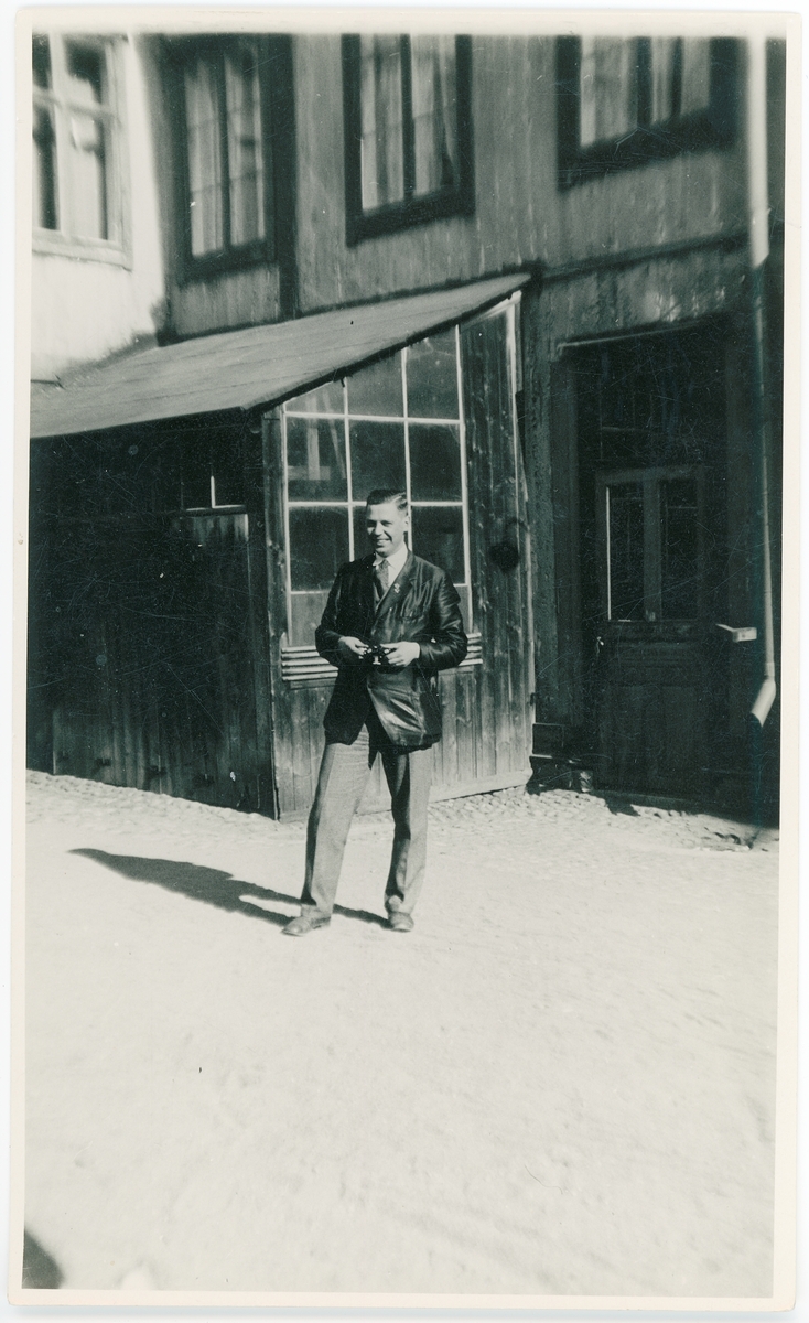 En man står framför ett hus på en innergård, Uppsala