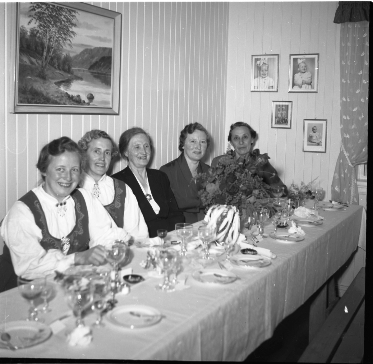 Bilde av penkledde gjester sittende til bords. Bryllupsfest?