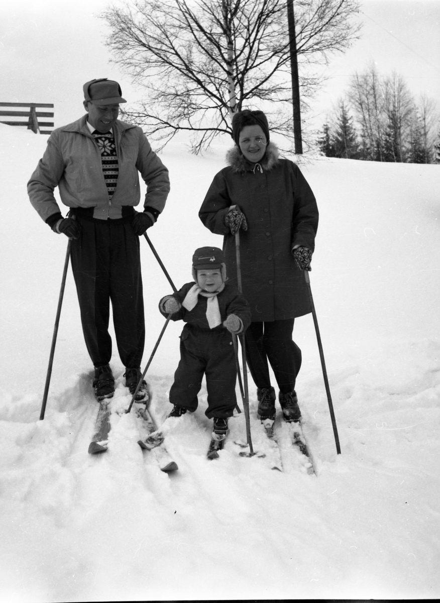 En mann, kvinne og liten gutt på ski.
