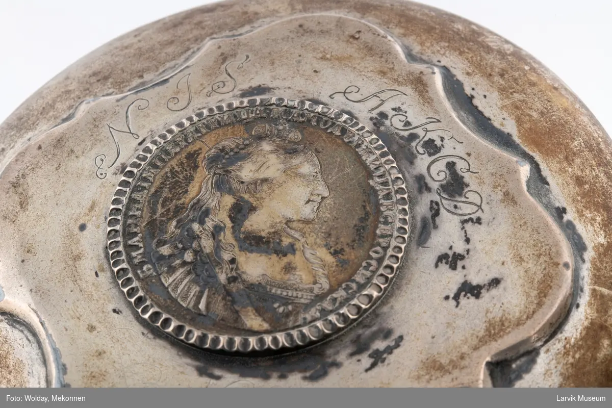 Krus i Steintøy med sølvlokk med gravering og mynt i lokket