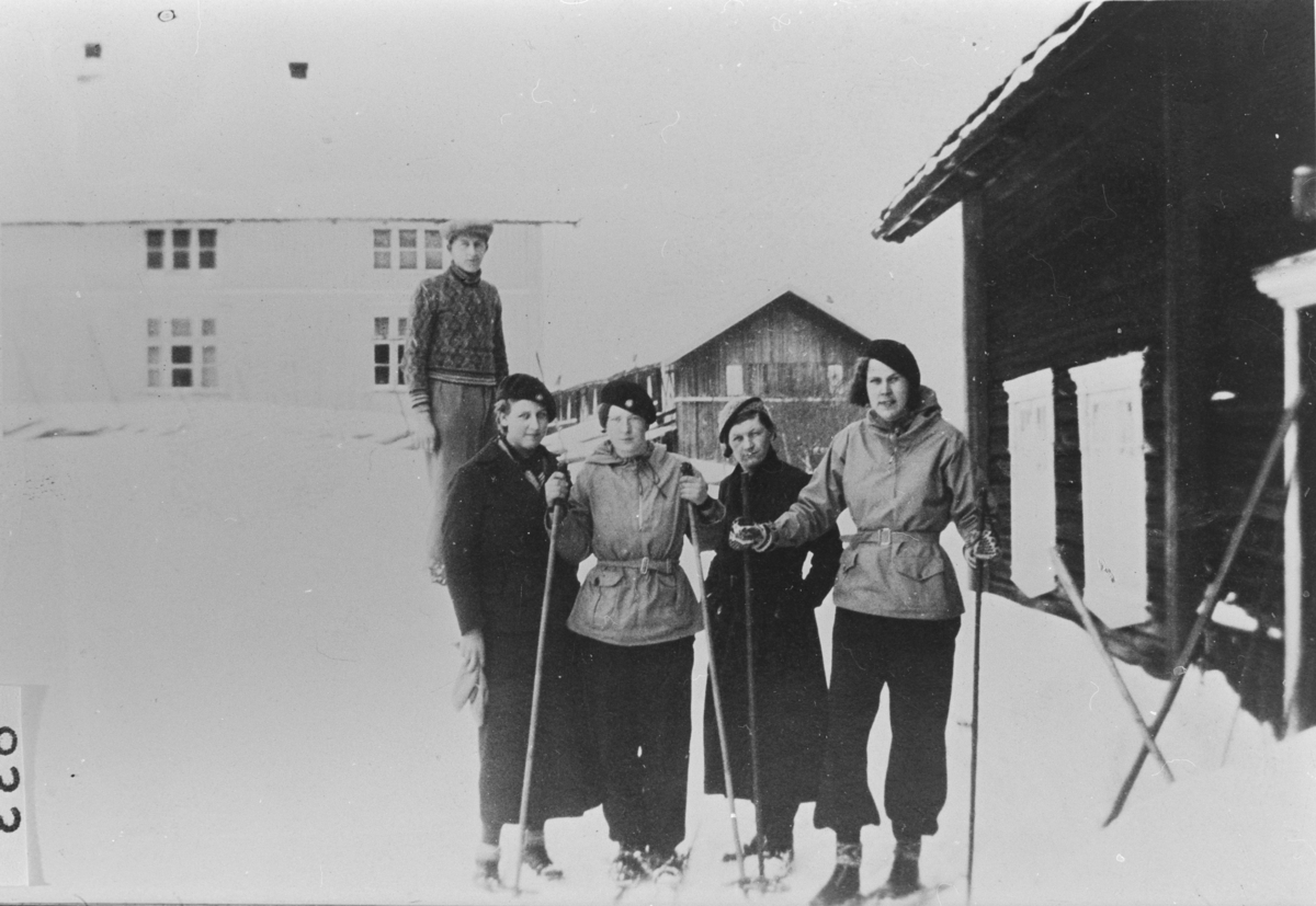 Skirenn i Velstadbakken, med husene på Velstad i bakgrunnen. Erling Langerud, Gudrun Kopseng, Helga Ødegård, Gjertrud Velstad og Kristine Green. 1930-årene.