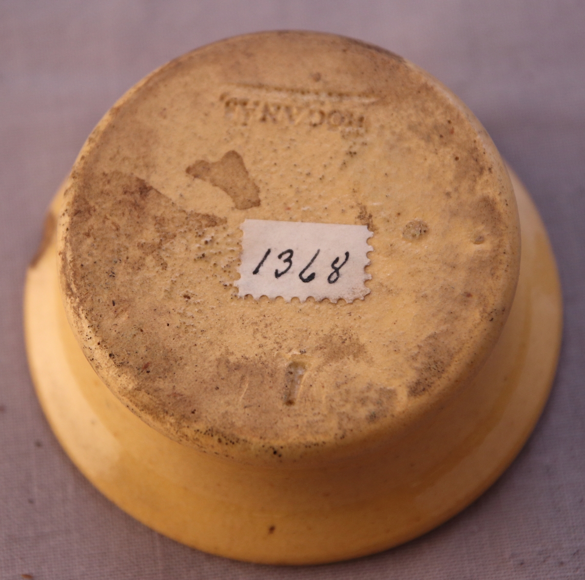 Sanddosa i keramik med gul glasyr.  Stämplat ”1” (möjligtvis förstahandssortering?) och ”Höganäs” undertill.