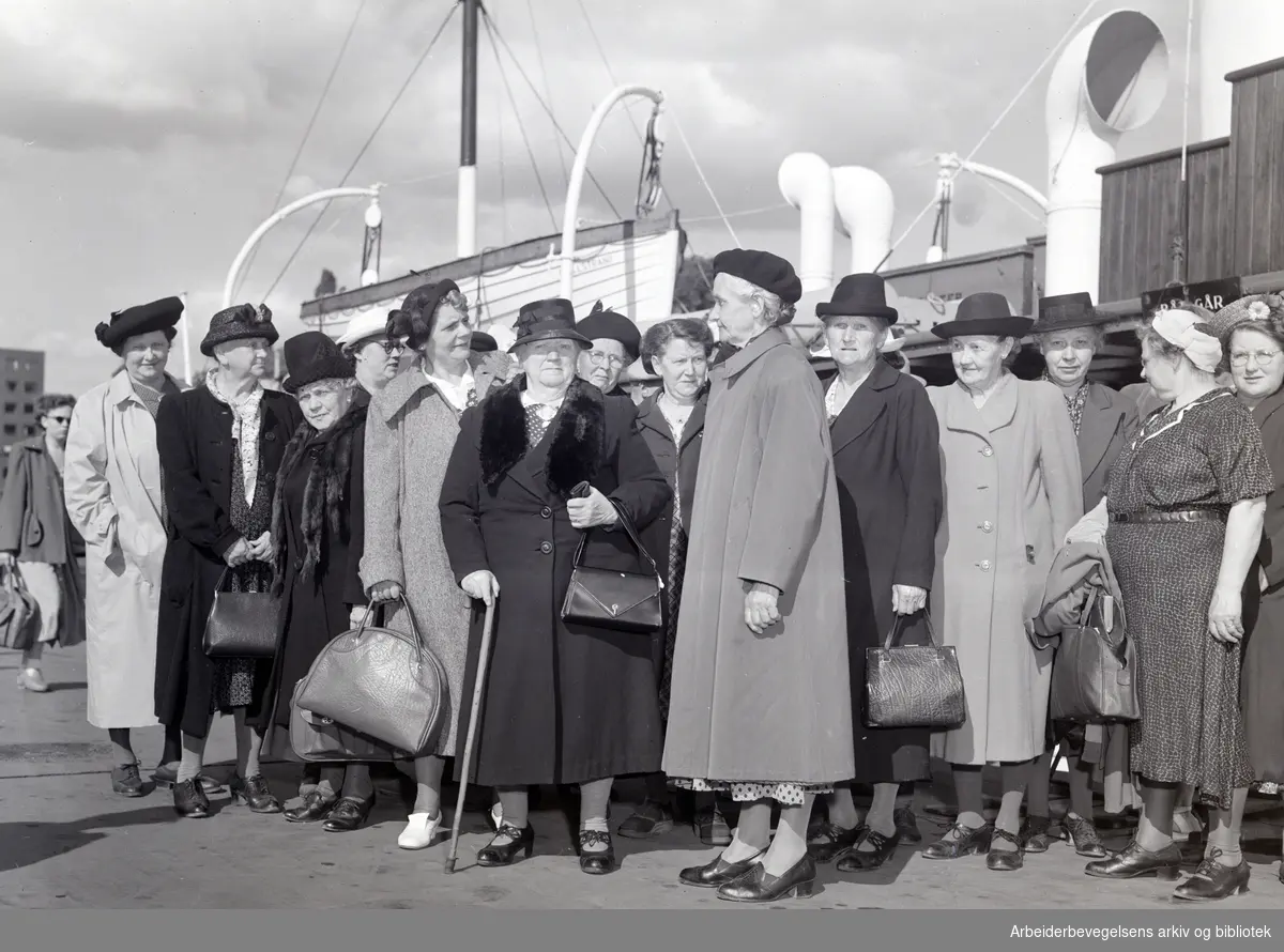 Husmorferie. 30 godt voksne husmødre venter på båten som skal frakte dem over til Feriehjemmet for slitne husmødre på Svestad, Nesodden. Rådhusbryggene. Juni 1951.