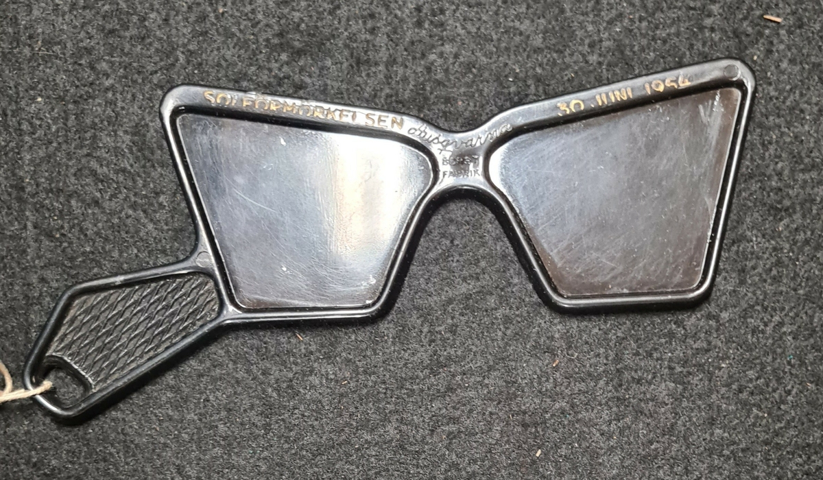 Mörka glasögon i plast. Plasten är näst intill ogenomskinlig. 
Framtagna som skydd för ögonen vid solförmörkelse. Dessa tillverkades specifikt för solförmörkelsen 1954.