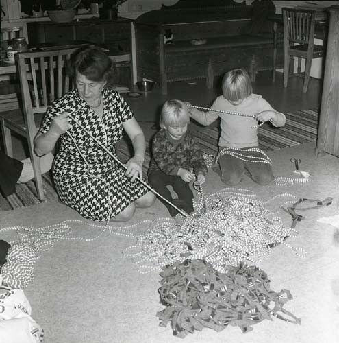 Hemma i Sunnanåker, mellan 1975-1977. Adéle nystar mattrasor tillsammans med två av barnbarnen.
