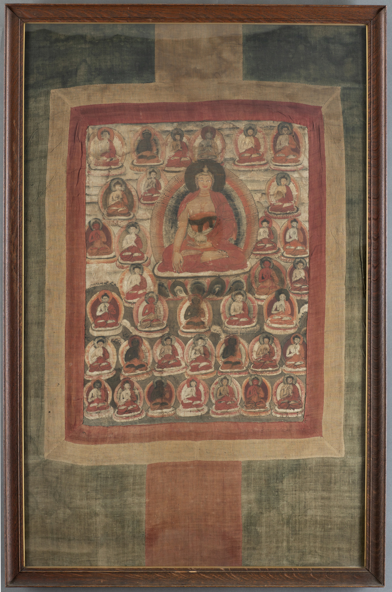 Vertikalt maleri på tekstil, satt i ramme. 
Tibetansk mandala.