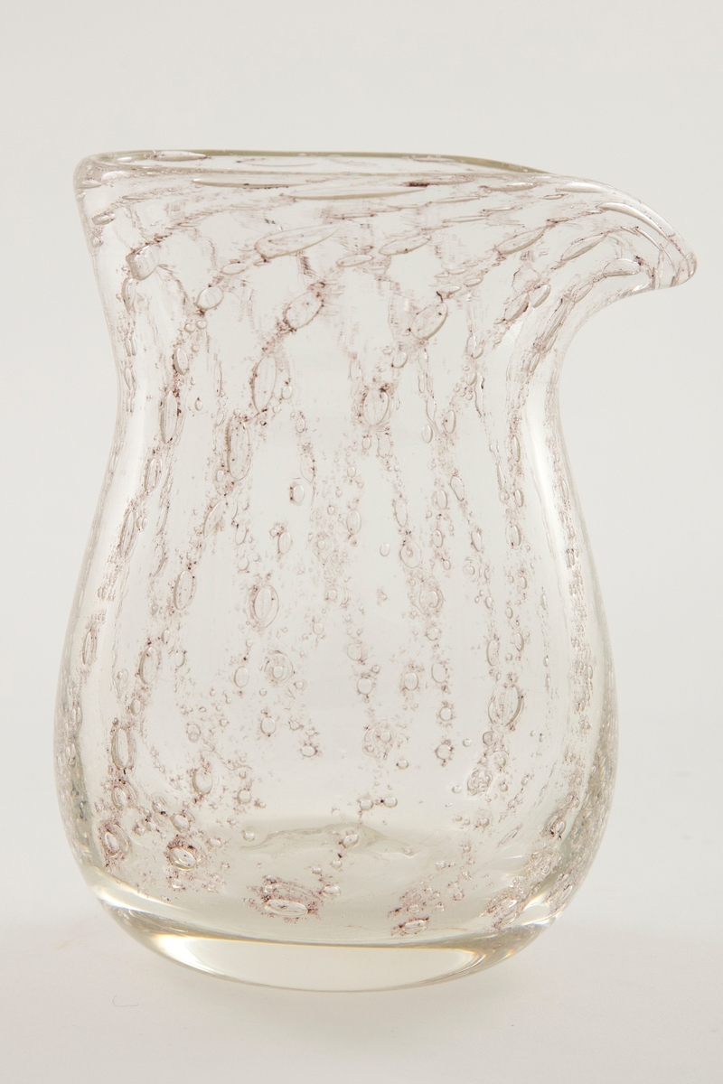 Mugge i klart glass med mønster av luftbobler. Boblene danner et spiralmønster i glasset som følger muggens form.