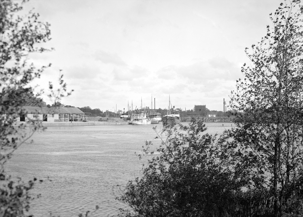 Utblick mot Linköpings hamn omkring år 1930, där Göta kanalångaren THORE är på ingång och passerar JUPITER, LINKÖPING och KINDA. Till vänster ses hamnkontoret med magasin som uppfördes 1925. Vy mot norr.