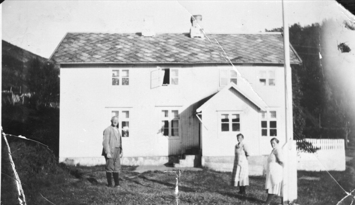 Gården til Joakim Nathanielsen i Grovfjord. Tre personer står på gårdstunet.