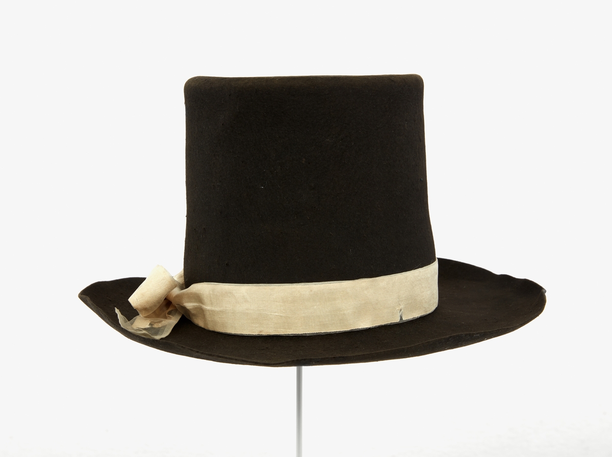 Hatt tillhörande Gustav III:s daluniform. Hög hatt av svart filt. Ombunden med vitt sidenband, knutet i dubbelögla med långa ändar.