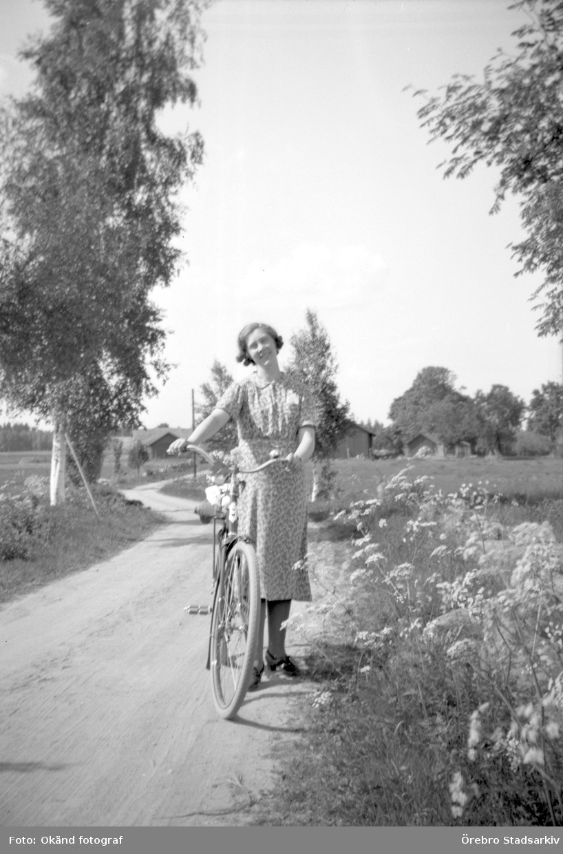 Kvinna med cykel på landsväg